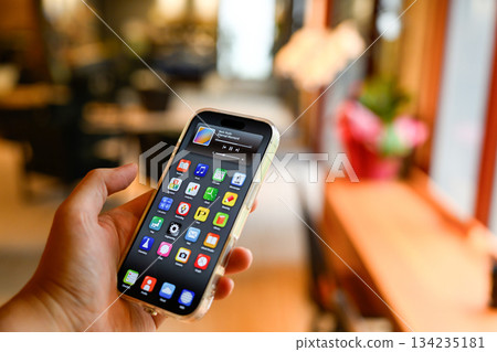 Operate a smartphone at a cafe 134235181