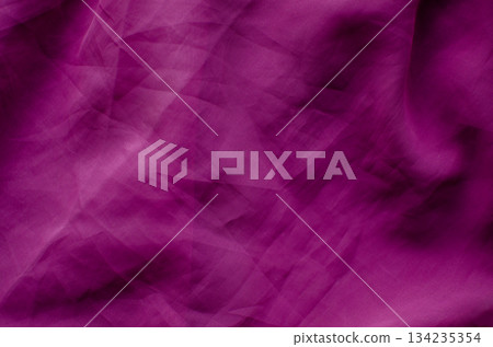 A full-frame abstract background featuring wrinkled magenta fabric with a visible woven texture. The surface is characterized by soft folds, crumpled creases, and deep shadows, creating a vibrant 134235354