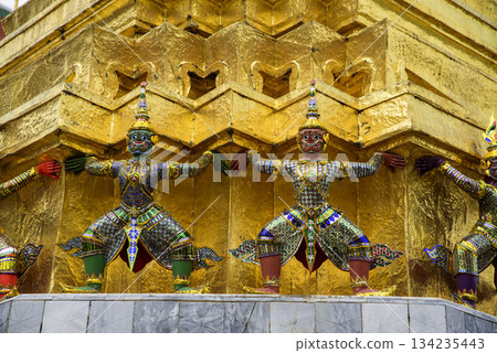 The gold statues of the four-armed figures are on a building The gold statues of the four-armed figures are on a building 134235443