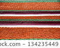 Red and green roof with a pattern of orange tiles 134235449