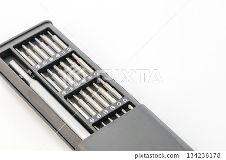 A gray screwdriver set with various silver bits is arranged neatly in a black case. 134236178