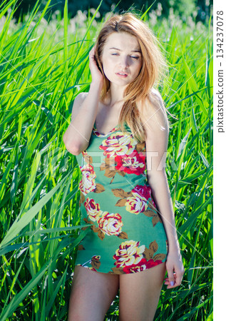 Fashion Art Photo. Model Girl Portrait in Moonlight at Night. Sexy Glamour Mystical Beautiful Woman in blue dress standing in canes against water background. Beautiful fashion creative shot. Fashion Art Photo. Model Girl Portrait in Moonlight at Night. Sexy Glamour Mystical Beautiful Woman in blue dress standing in canes against water background. Beautiful fashion creative shot. 134237078