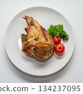 Top-view roasted chicken portion with parsley and tomatoes on a white plate. Suitable for food advertising, menus, recipe layouts, healthy lifestyle visuals and editorial uses 134237095