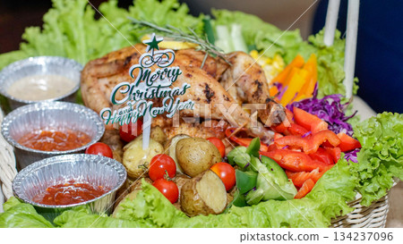 Roast chicken platter with vegetables, potatoes and Christmas decorations. Suitable for seasonal ads, festive menus, catering catalogs and winter holiday materials. 134237096