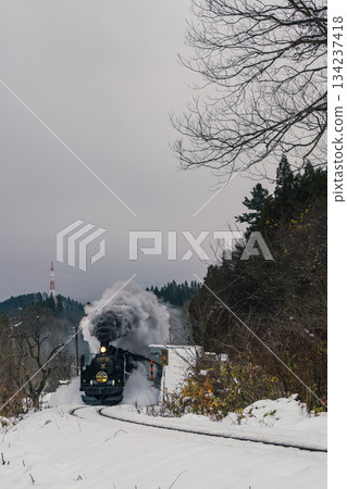 The SL Banetsu Monogatari steam locomotive powers its way through the snow in Aga Town, Niigata Prefecture. 134237418