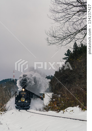 The SL Banetsu Monogatari steam locomotive powers its way through the snow in Aga Town, Niigata Prefecture. 134237427