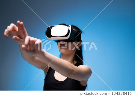 Virtual reality designer extending hands to interact with immersive digital interface and creative workspace 134238415