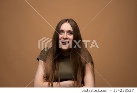 Delighted young woman reacting with joyful surprise, expressive emotional portrait on warm studio background 134238527