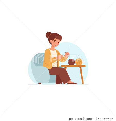 A woman engaged in the relaxing art of knitting while seated comfortably in her favorite armchair 134238627