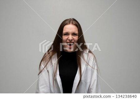 Woman shouting with intense emotional anger in expressive dramatic studio portrait 134238640