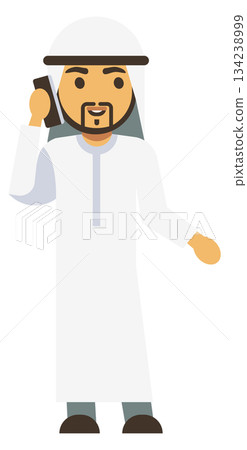 A man in a white robe is talking on a cell phone 134238999
