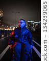 Pensive young man with disability strolling late at night in wheelchair in red blue rgb neon light. 134239065