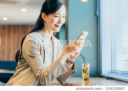 在一家咖啡館經營智能手機的女商人 134239087