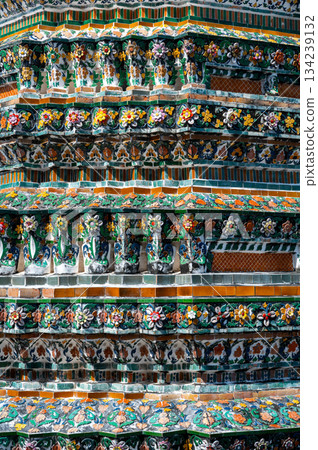 Detailed view of the ornate towers of Wat Arun in Bangkok, Thailand, showcasing rich ceramic floral patterns, sculpted figures, and intricate decorations under bright daylight. Detailed view of the ornate towers of Wat Arun in Bangkok, Thailand, showcasing rich ceramic floral patterns, sculpted figures, and intricate decorations under bright daylight. 134239132