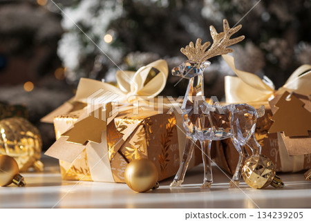 Crystal Reindeer with Gold Antlers and Christmas Gifts in Festive Interior 134239205