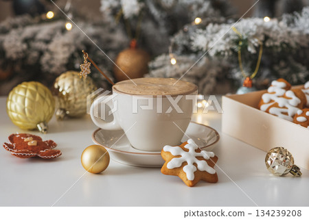 Cup of Hot Coffee with Christmas Gingerbread Cookies and Ornaments in Festive Setting Cup of Hot Coffee with Christmas Gingerbread Cookies and Ornaments in Festive Setting 134239208