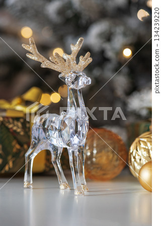 Crystal Reindeer with Gold Antlers and Christmas Gifts in Festive Interior 134239220