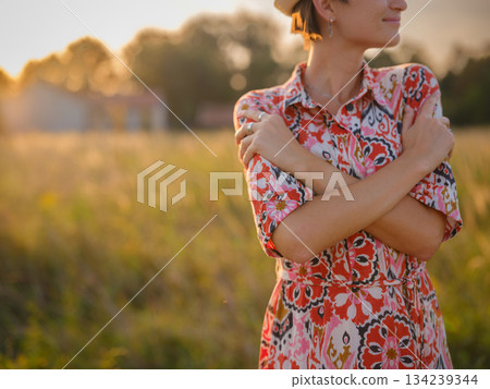 young woman embracing herself, self-love in action, mental health advocate, practicing self-care for finding inner peace, in European countryside 134239344