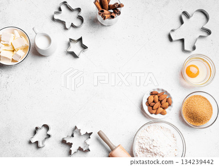 Christmas baking background with baking ingredients and cookie cutters Christmas baking background with baking ingredients and cookie cutters 134239442