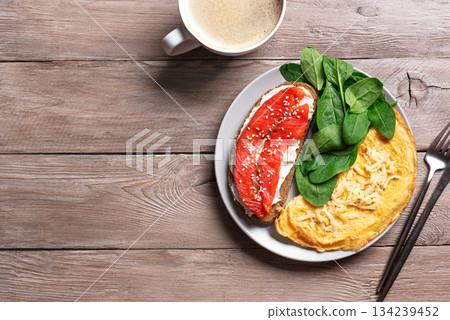 Healthy keto breakfast. Omelette, sandwich with salmon, spinach. 134239452