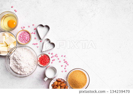 Valentine day baking background with heart shaped cookie cutters Valentine day baking background with heart shaped cookie cutters 134239470