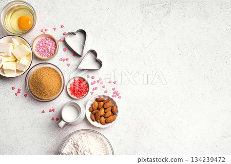 Valentine day baking background with heart shaped cookie cutters Valentine day baking background with heart shaped cookie cutters 134239472