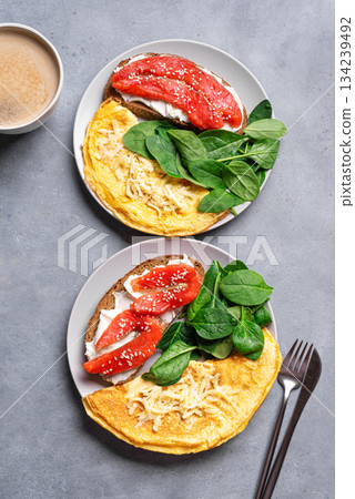 Healthy breakfast for two. Omelette, sandwich with salmon, spinach. 134239492