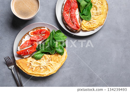 Healthy breakfast for two. Omelette, sandwich with salmon, spinach. 134239493