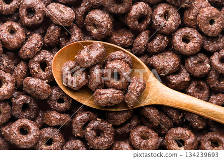 Chocolate corn rings in a wooden spoon background. Top view 134239693
