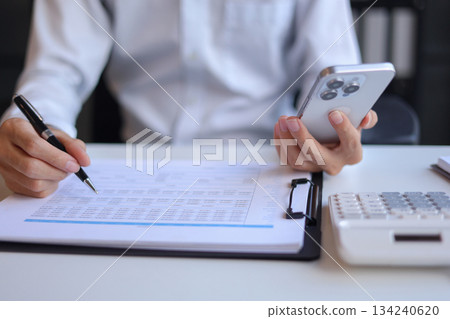 Businessman working in office using smartphone. Businessman working in office using smartphone. 134240620