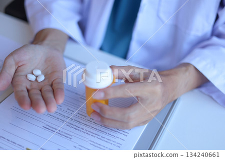 Doctor or General practitioner explain to patient how to use prescribed medicine correctly 134240661