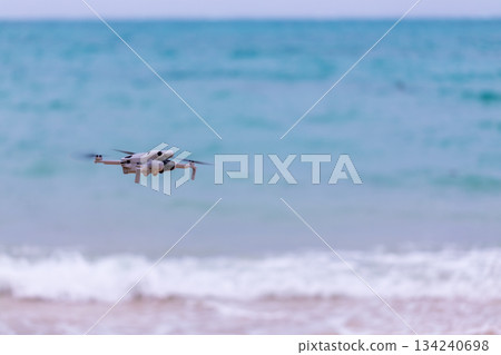 小型無人機在沖繩海灘上空準備起飛進行航拍任務 134240698