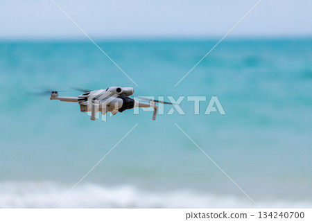 小型無人機在沖繩海灘上空準備起飛進行航拍任務 134240700