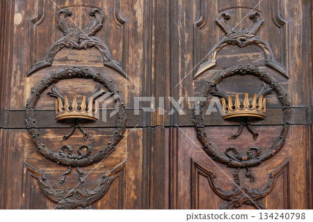 Antique wooden door detail with crown carving Antique wooden door detail with crown carving 134240798