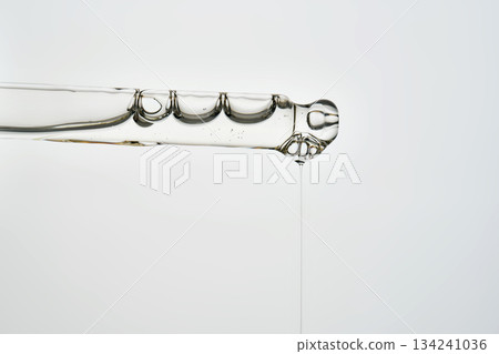 Cosmetic pipette dispensing serum creating bubbles and drip 134241036