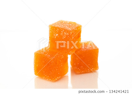 Three orange cubes of marmalade candy on a white background Three orange cubes of marmalade candy on a white background 134241421