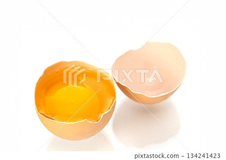 An egg is cracked open, revealing its yellow yolk An egg is cracked open, revealing its yellow yolk 134241423