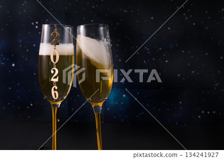 New Year Celebration. Two champagne glasses against a starry backdrop celebrating 2026. New Year Celebration. Two champagne glasses against a starry backdrop celebrating 2026. 134241927