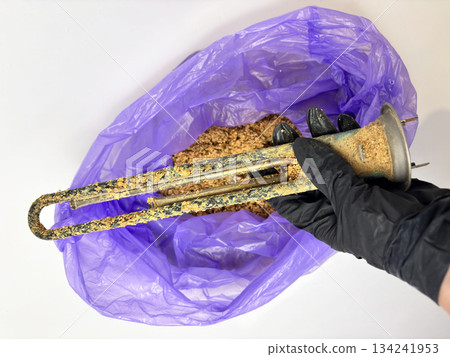 Plumber hand holding a boiler heating element covered with limescale, hard water residue, boiler maintenance and cleaning, scale removal, water heater repair 134241953
