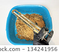 Plumber hand holding a boiler heating element covered with limescale, hard water residue, boiler maintenance and cleaning, scale removal, water heater repair 134241956