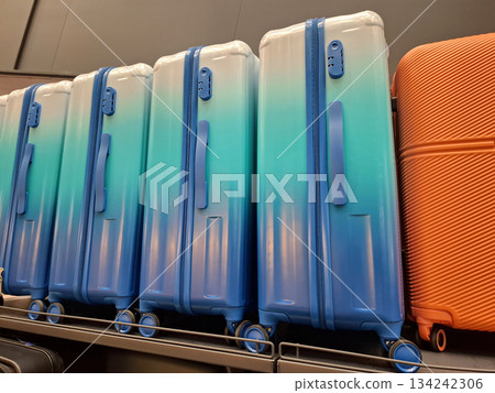 Large suitcases are on counter in store. Suitcases are sold in supermarket 134242306