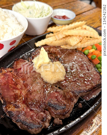 Juicy T-bone steak served with rice, french fries, and mixed vegetables Juicy T-bone steak served with rice, french fries, and mixed vegetables 134242362