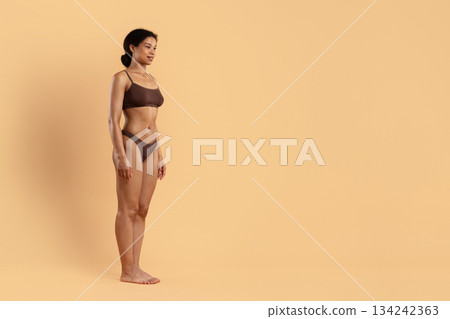 Side view pose of young fit black woman in brown underwear 134242363