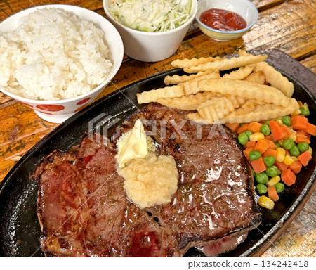 Juicy T-bone steak served with rice, french fries, and mixed vegetables Juicy T-bone steak served with rice, french fries, and mixed vegetables 134242418