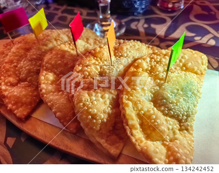 Crisp chebureki served with colorful flags at a cozy dining spot 134242452