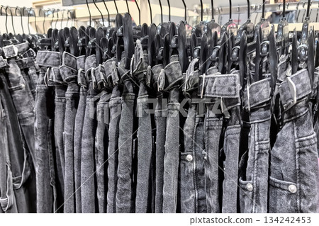 Stylish black jeans hanging neatly in a modern clothing store 134242453
