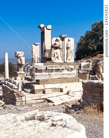 Ancient ruins of ephesus city in turkey, displaying impressive marble column fragments and carved statues standing under a clear blue sky, evoking history and travel destinations Ancient ruins of ephesus city in turkey, displaying impressive marble column fragments and carved statues standing under a clear blue sky, evoking history and travel destinations 134242831