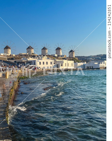 Mykonos' iconic white windmills embodying greek island culture, architecture, and tourism against a clear sky. Copy space Mykonos' iconic white windmills embodying greek island culture, architecture, and tourism against a clear sky. Copy space 134242851