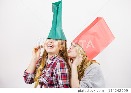 Two women wearing shopping bags on head Two women wearing shopping bags on head 134242999