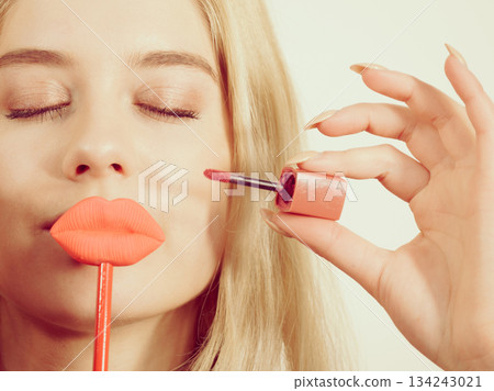 Woman applying lipstick or lip gloss Woman applying lipstick or lip gloss 134243021